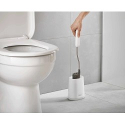 Escobilla de baño Joseph Joseph Flex Lite en su soporte blanco junto al inodoro