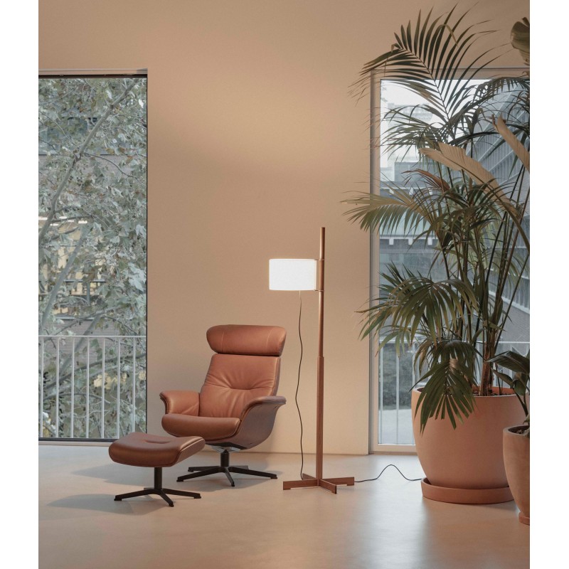 Sillón giratorio Conform Timeout en piel cognac con reposapiés junto a la ventana